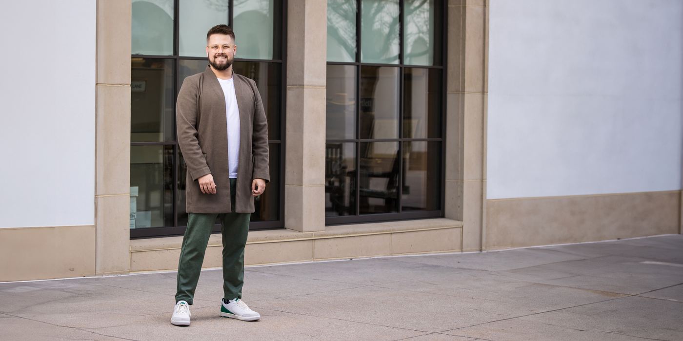 Colin Rickard standing outside a stone and glass building